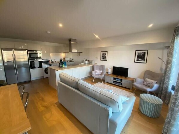 Un appartement moderne comprenant une cuisine, un salon et un coin repas.
