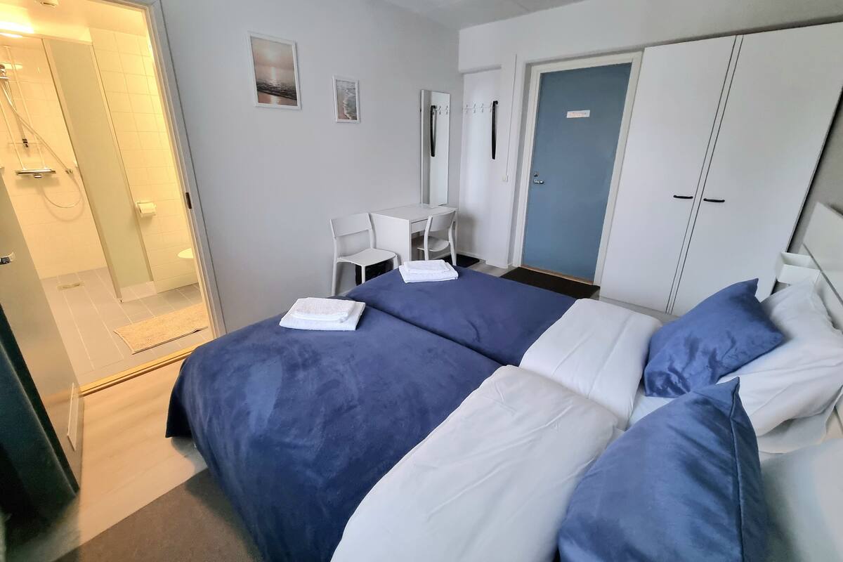 Une chambre d’hôtel équipée d’un lit, d’un bureau et d’un espace douche.