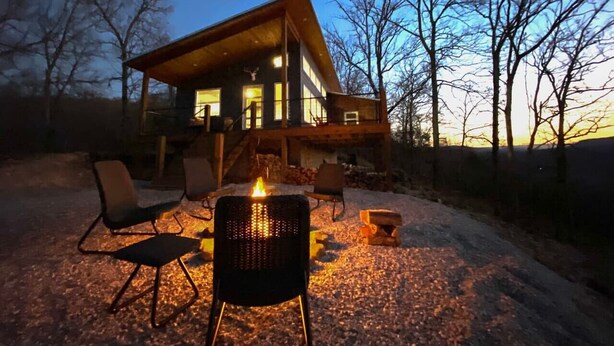A cabin with a fireplace, outdoor seating, and a deck. - The Aerie ~ A Modern Retreat at Double Bridges (Mountain View)