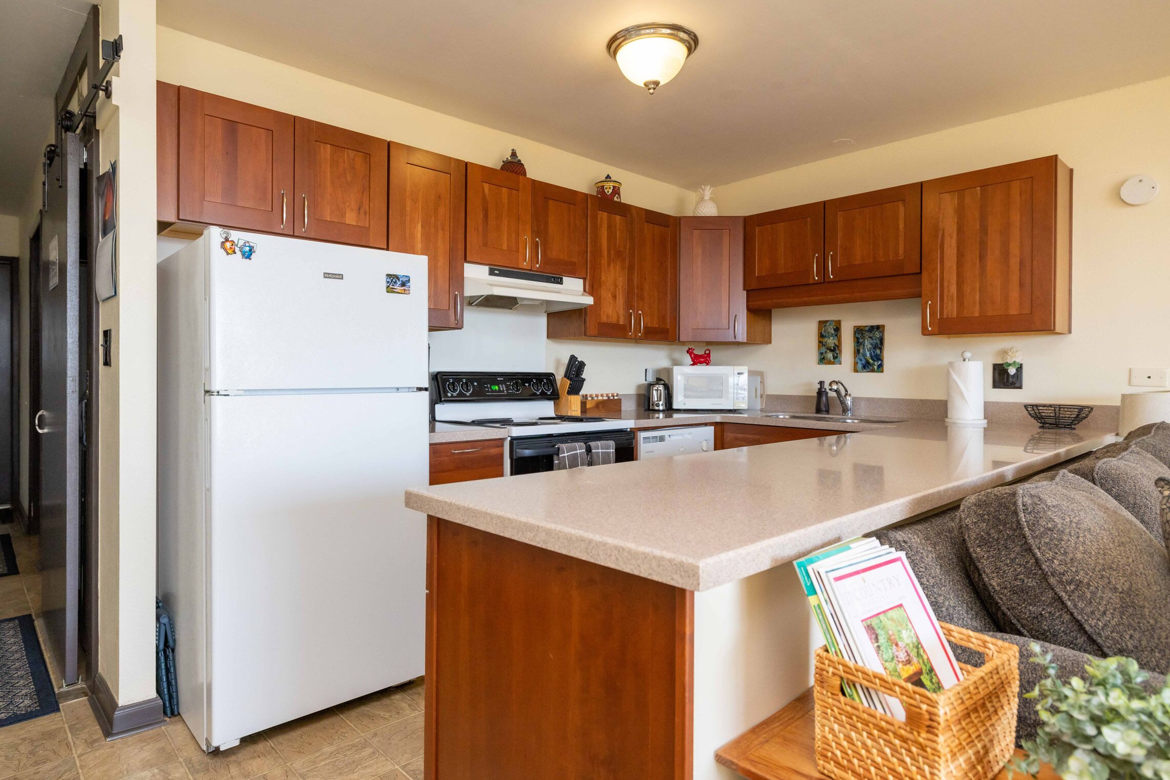 A kitchen with wooden cabinets, a white refrigerator, a stove, and a microwave.