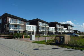 A modern apartment building with multiple balconies and large windows. - A Beachlife by the sea in Callantsoog - LekkerNaarZee (Callantsoog)