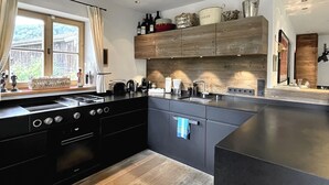 Eine moderne Küche mit einer großen Kochinsel, schwarzen Schränken und Holzboden.