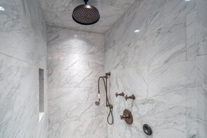A modern bathroom with marble walls, a showerhead, and a handheld shower attachment. - Stunning 4-Bedroom Private Penthouse Villa With Panoramic Views (Mountain Village)