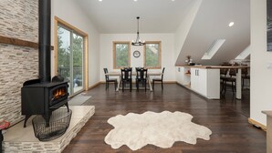 A spacious living area with a fireplace, dining table, and kitchen island.