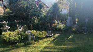 Un jardín con faroles de piedra, una estatua de Buda y una estructura al estilo de pagodas.