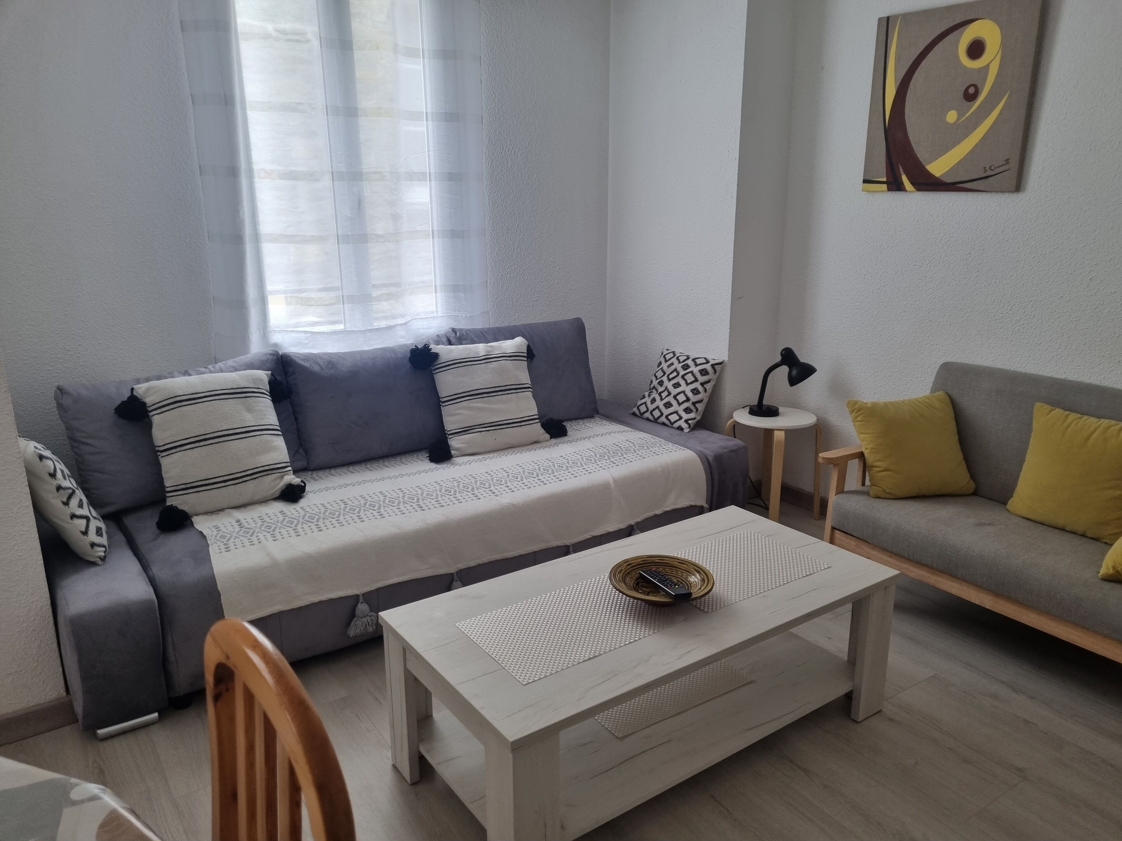 A modern living room with a sofa, a coffee table, and a lamp.