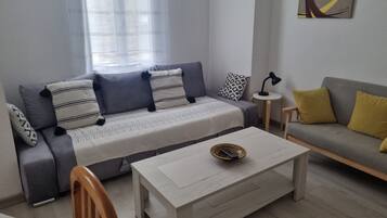 A modern living room with a sofa, a coffee table, and a lamp.
