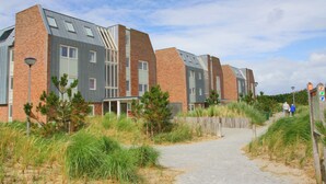 Een modern gebouw met een bakstenen gevel en grote ramen.