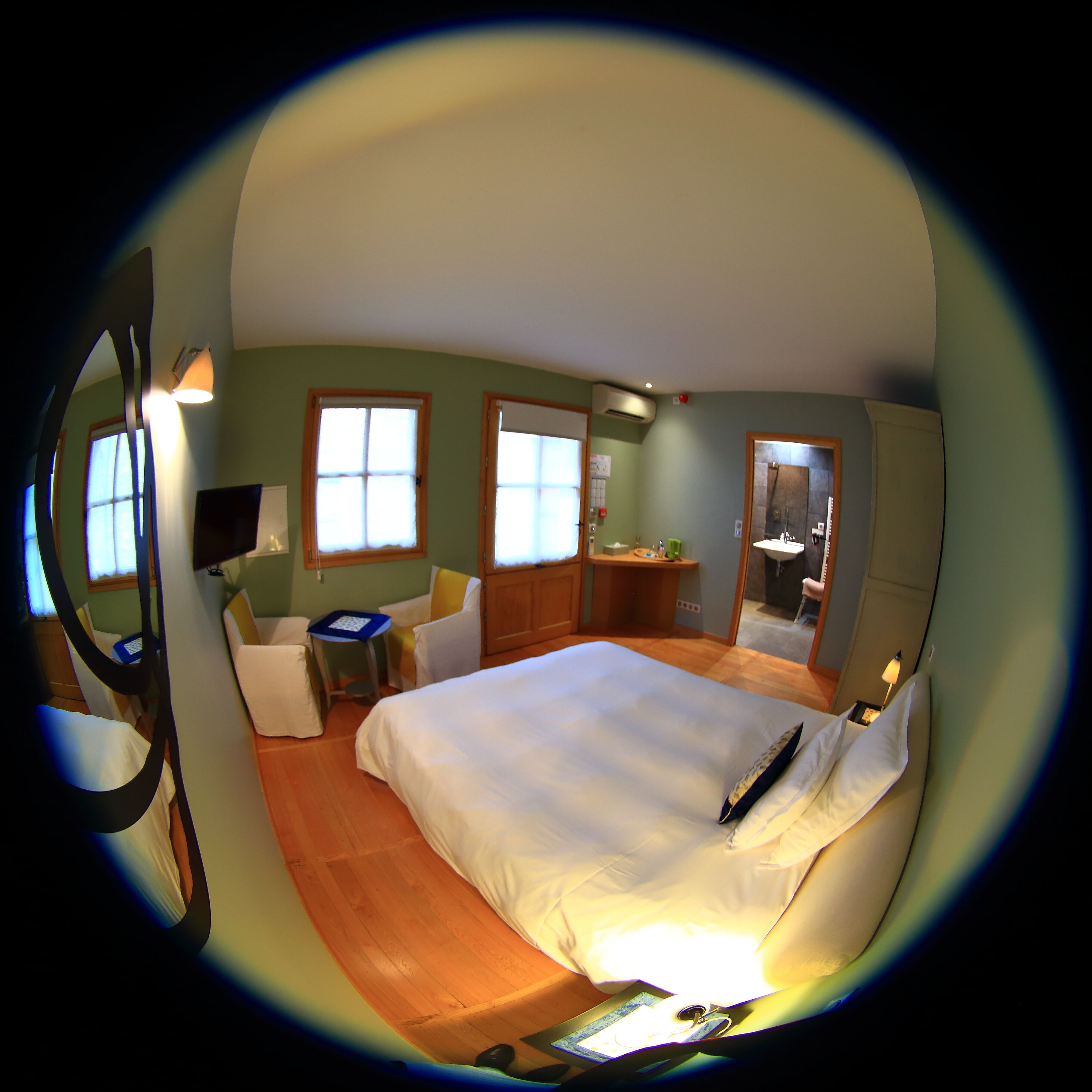 A room with a bed, a desk, a chair, a mirror, and a window.