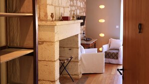 A cozy living area with a fireplace, a sofa, and a coffee table. - Hôtel Restaurant Le Jardin des chouchoux Brantôme  (Brantôme en Périgord)