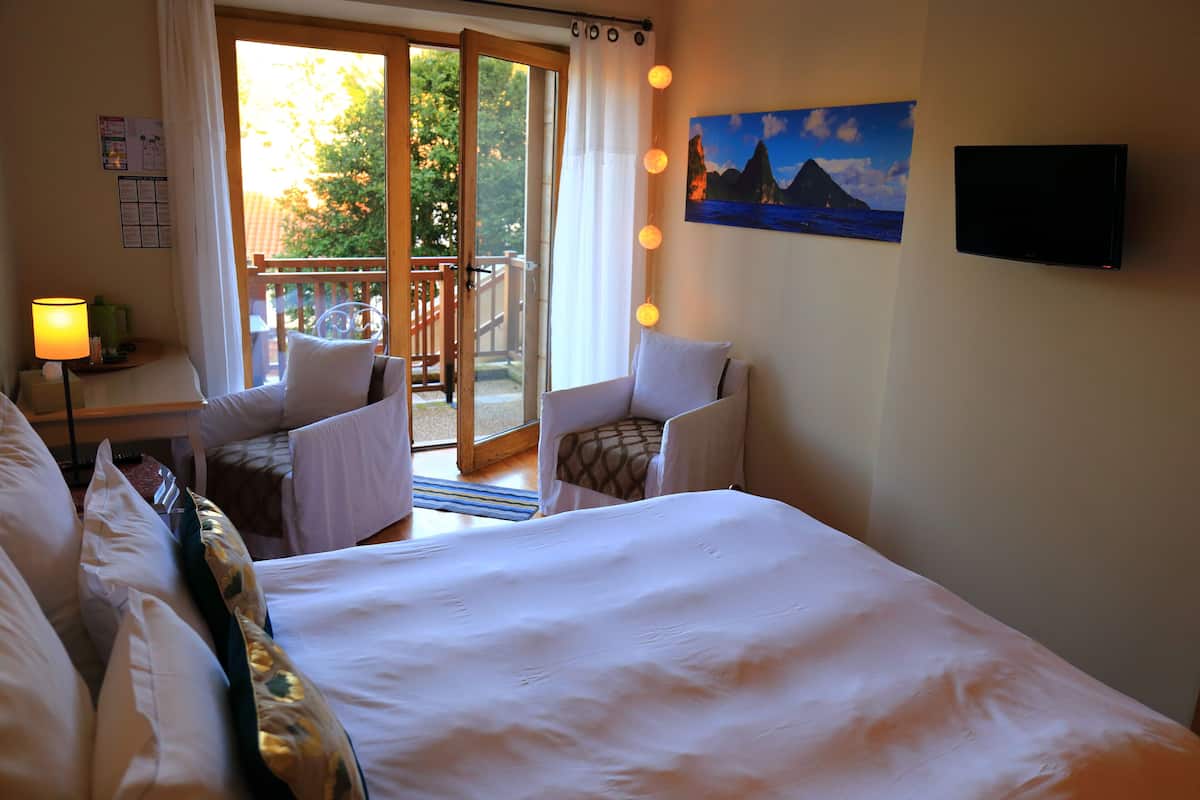 Habitación de hotel con una cama grande, un escritorio con lámpara, una silla y un cuadro en la pared.