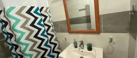 Een douche, handdoeken, zeep, toiletpapier