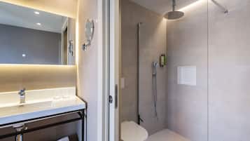 Un baño moderno con un lavabo, espejo y retrete blancos.