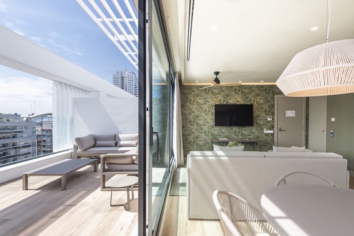 A modern balcony with a sofa, chairs, and a table.