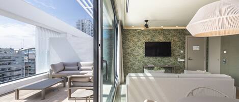 A modern balcony with a sofa, chairs, and a table.