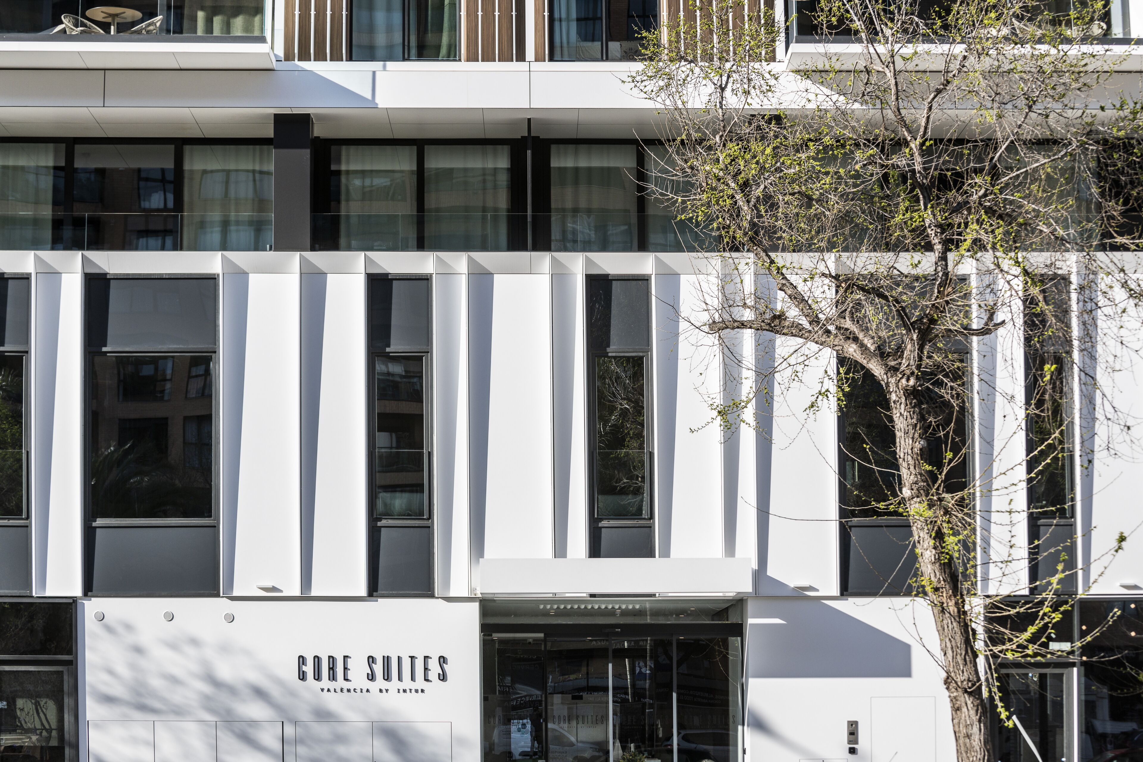 A modern building with a sign reading "CORE SULITES VALENCIA BY INNEX."