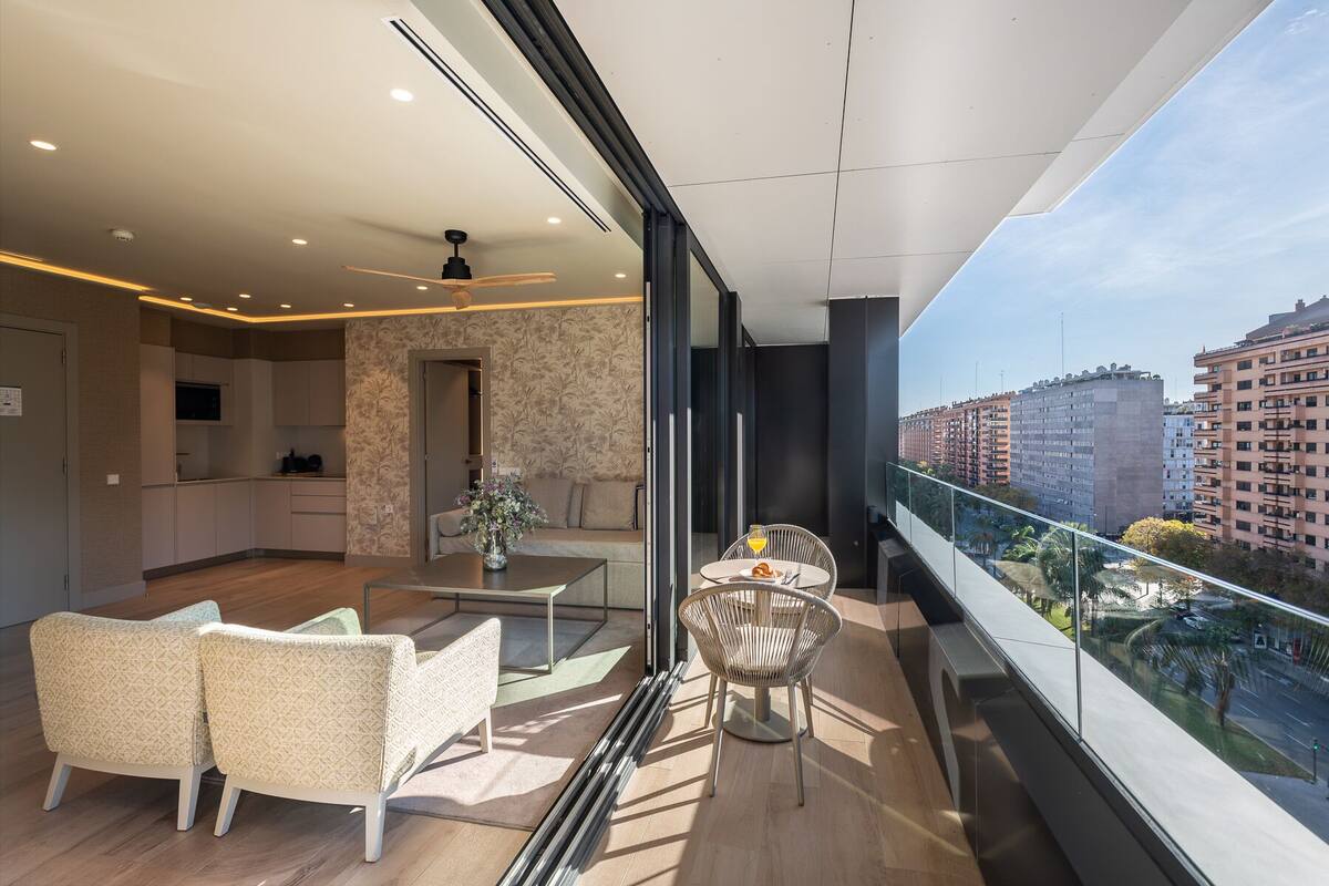 A modern apartment with a balcony, a dining area, and a kitchen.