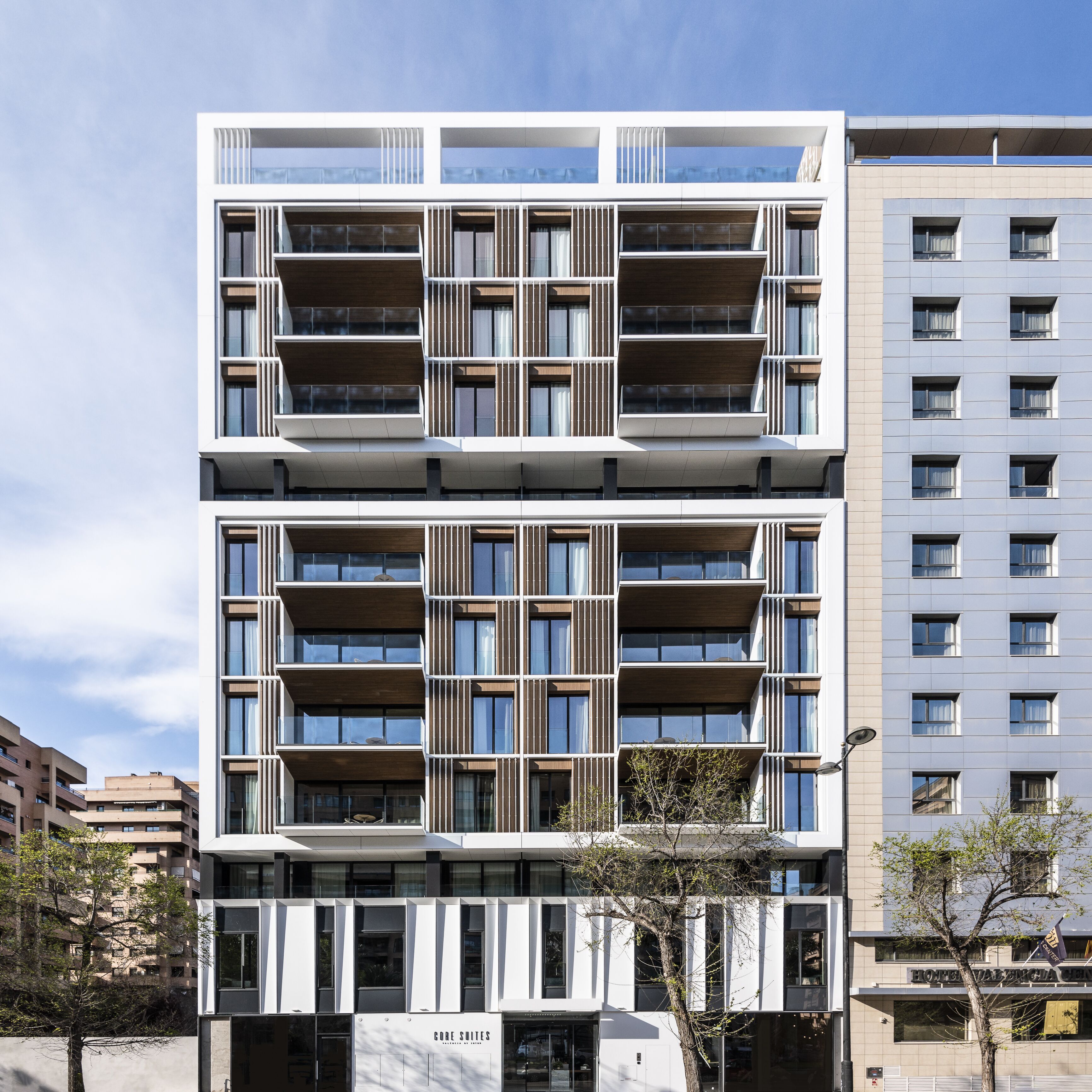 Un hotel de varios pisos con un diseño arquitectónico moderno, con balcones y ventanas amplias.