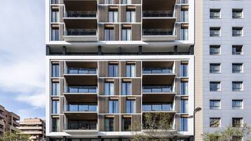 Un hotel de varios pisos con un diseño arquitectónico moderno, con balcones y ventanas amplias.