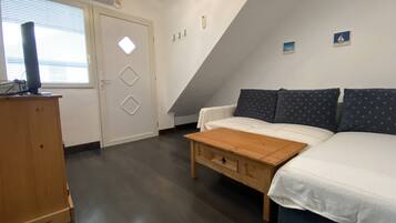 Une pièce comprenant un lit, un bureau, une chaise, une fenêtre et une porte.