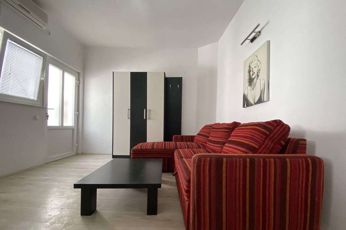 A living room with a sofa, a coffee table, and a wardrobe.