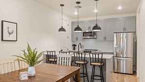 A modern kitchen with grey cabinets, stainless steel appliances, and pendant lighting. - Adventures at the Cowabungalow #82 by RedAwning (St. George)