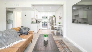 Un apartamento moderno con sala de estar, kitchenette y comedor.