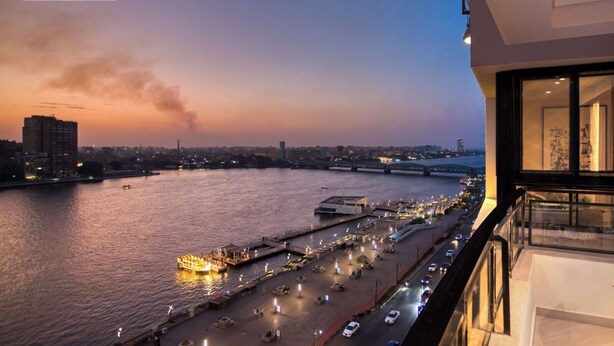 A waterfront view from a hotel balcony with a river, a bridge, and cityscape in the background. -  Prime Residence Arkadia (Cairo)