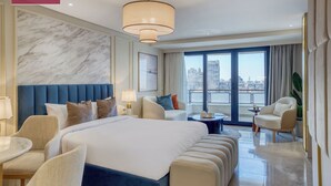 A modern hotel room with a large bed, seating area, and a view of the city. -  Prime Residence Arkadia (Cairo)