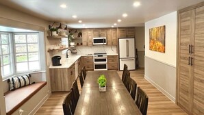 A modern kitchen with wooden cabinets, a dining table, and built-in appliances. - Relax and Unwind. Location! Location! Location!Family-friendly. Outdoor space. (Ouray)
