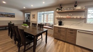 A modern kitchen with a wooden dining table, built-in cabinets, and a countertop with a coffee maker. - Relax and Unwind. Location! Location! Location!Family-friendly. Outdoor space. (Ouray)