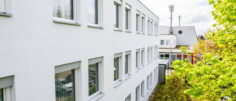 Un edificio de varios pisos con paredes exteriores blancas y múltiples ventanas.