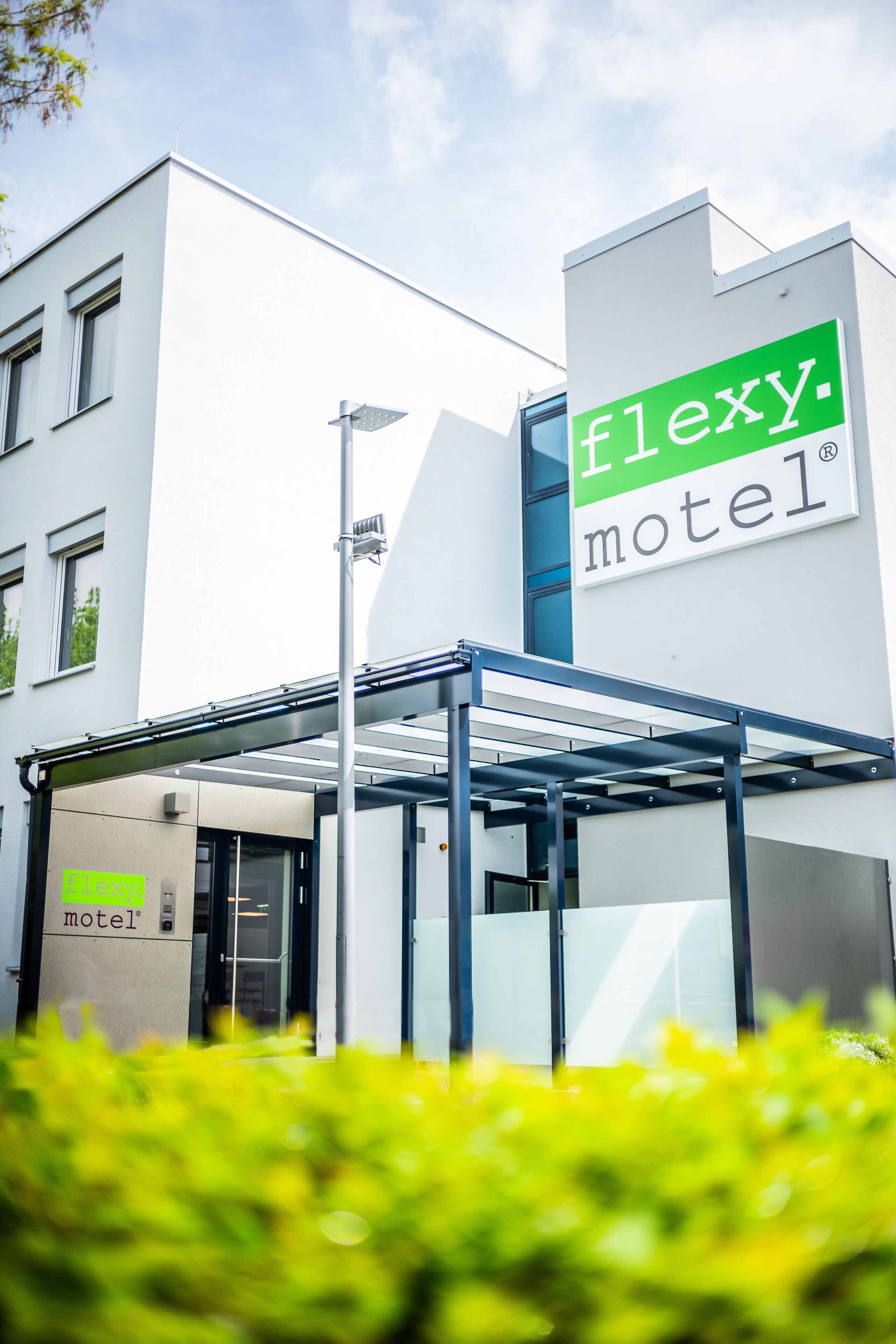 A modern building with a sign reading "flexy motel".