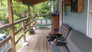 Een overdekte veranda met een houten bank en een kleurrijke bank.