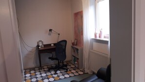 A small, narrow room with a desk, chair, and radiator. - Apartment "Blume" Vacation made for me (Fahrenbach)