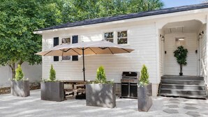 A patio area with a grill, outdoor seating, and planters. - Stylish Monthly 1BR Downtown Rental (Charleston)
