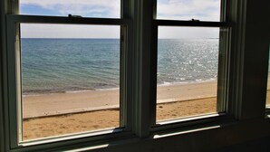 A view through two windows of a beach with a clear sky. - Water Front Days Cottage #15 (2255) (North Truro)