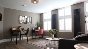 Una sala de estar moderna con comedor, ventanas amplias y una lámpara de techo.