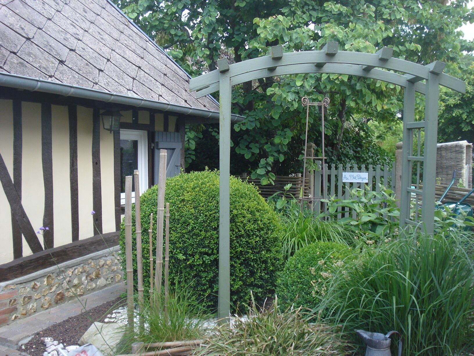 Une maison traditionnelle avec un toit à pignon, une clôture en bois et une enseigne indiquant : « Un endroit pour se reposer ».