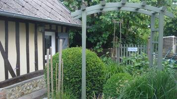 Une maison traditionnelle avec un toit à pignon, une clôture en bois et une enseigne indiquant : « Un endroit pour se reposer ».