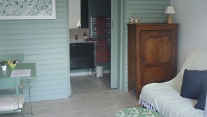 Une pièce comprenant un bureau, une chaise, un lit, une armoire en bois et un chapeau accroché au mur.