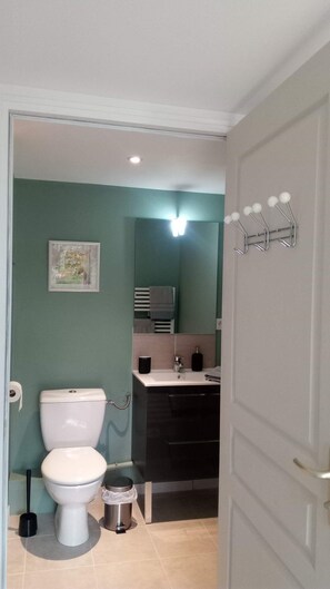 Ein Badezimmer mit Toilette, Waschbecken und Spiegel.