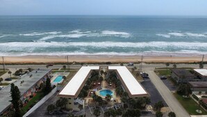 A hotel with a pool, a beach view, and a parking lot. - Remodeled Beach Oasis (Ormond Beach)