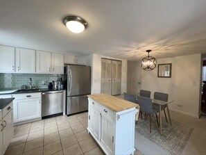 Enjoy meals in the kitchen with stainless steel appliances and ample workspace, complemented by a dining area with a table and four chairs.