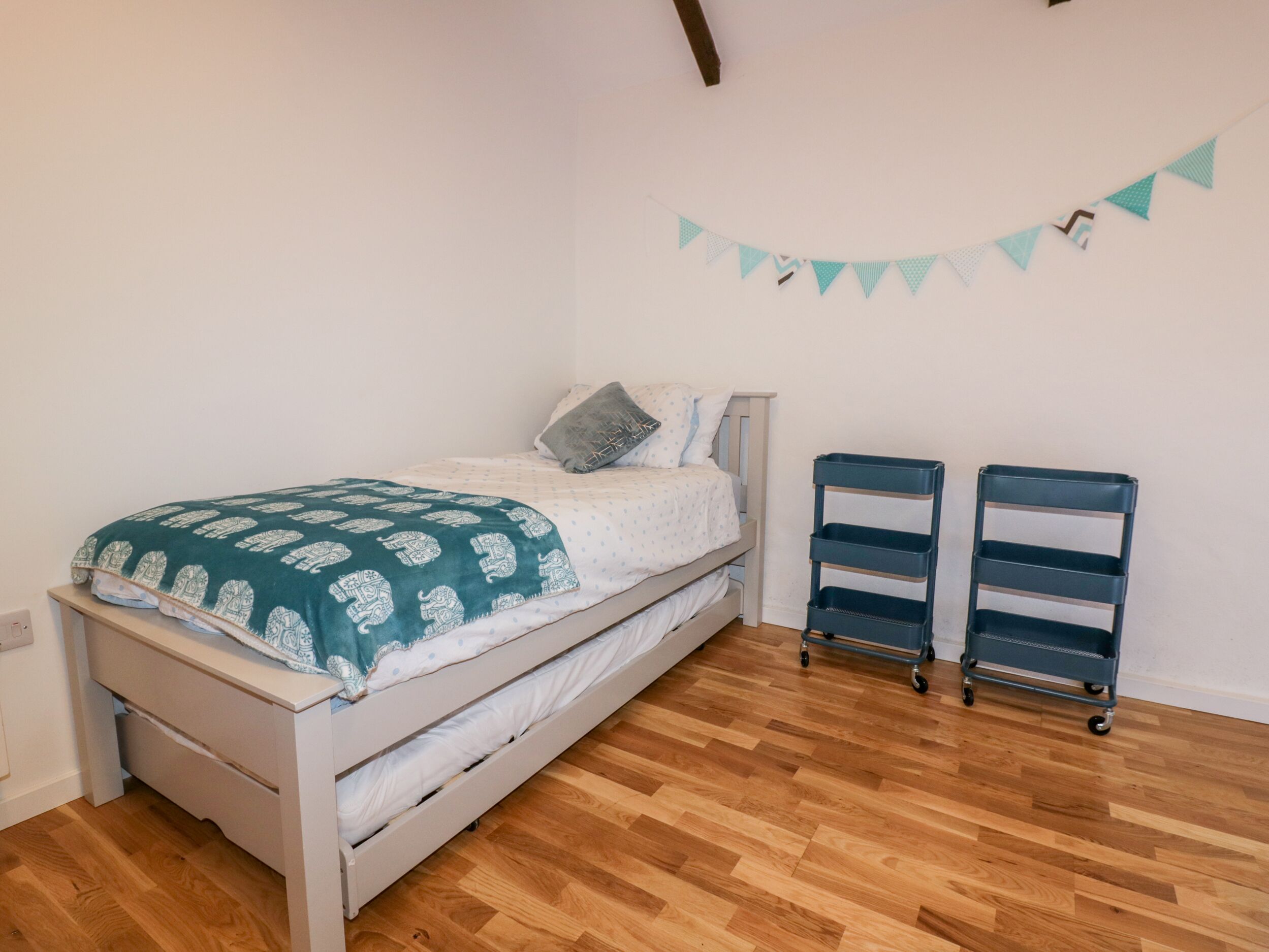 A bedroom with a bed, two storage units, and a wall-mounted decoration.
