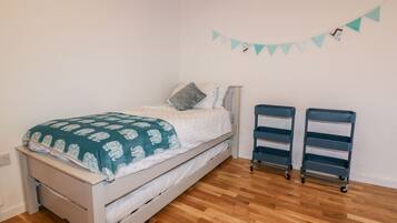 A bedroom with a bed, two storage units, and a wall-mounted decoration.