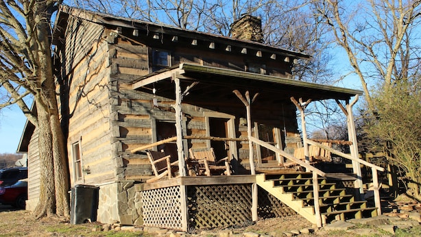 A rustic log cabin with a wooden porch and steps leading to a covered area. - Step back in time a charming 1880 historic cabin (Jonesborough)