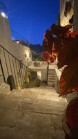 A staircase with a metal railing leading to a balcony.
