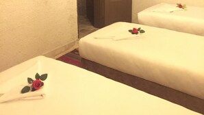Une chambre d’hôtel avec deux lits, un téléviseur fixé au mur et une porte donnant sur un placard.