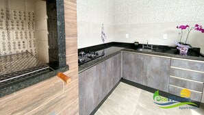 Una cocina moderna con estufa a gas, encimeras negras y armarios grises.